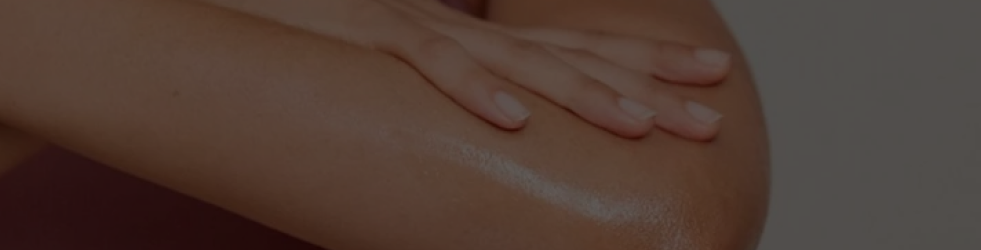 Close-up of glowing, clean arm being gently touched by a nourished hand — representing body nourishment, hydration, and skin wellness for desktop view