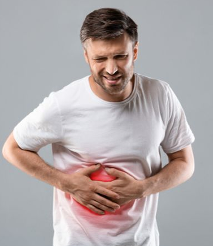 Man wearing a white T-shirt bent forward in pain, holding both hands on liver area — showing signs of liver discomfort