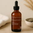 Back side of Brit Finds 100 ml castor oil bottle with droplet-shaped cap showing product instructions, ingredients, and usage details