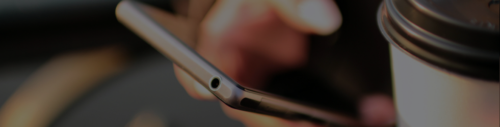 Contact banner showing a person with a coffee cup in one hand and a mobile phone in the other, representing convenient communication with Brit Finds on desktop