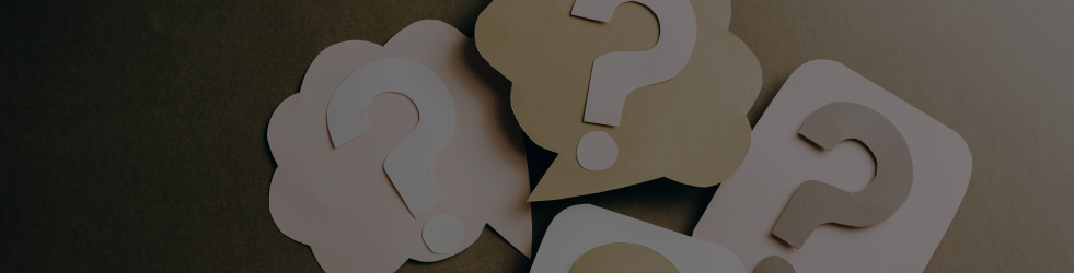 Banner for Brit Finds FAQ page showing three question marks made from computer paper, representing clear answers and customer support on desktop