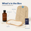 Contents of the Ancient Essence Castor Oil Kit displayed on a flat surface with blue arrows pointing to each item — includes 100 ml castor oil bottle, waist wrap, neck wrap, and hot and cold pack, with clear text at the top saying 'What's Inside the Box' 
