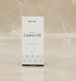 Closed box display of 200ml castor oil placed on a marble surface with a matching marble background, showcasing the elegant and premium packaging of the natural castor oil product.
